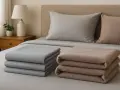 Piegati sul letto, due pile di lenzuola di flanella, grigie e color tortora. Forse le lenzuola di flanella fanno male al portafoglio, ma sono morbide.