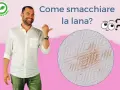 Uomo sorridente indica una macchia su tessuto di lana. Impara come smacchiare la lana con consigli pratici.