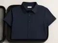 Camicia blu scuro piegata in una valigetta imbottita, un modo intelligente per capire come non stirare le camicie in viaggio.