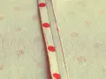 Tessuto a pois rossi con cucitura a vista, un punto per rifinire bordi con precisione sartoriale.
