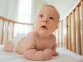 Bambino in culla, con pannolino, che esplora il mondo. Le misure lenzuolino culla sono perfette per questo piccolo esploratore.