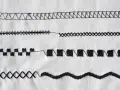 Close-up of various black sewing machine stitches on white fabric.