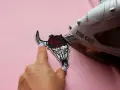 Come attaccare toppe termoadesive: un teschio di toro con rose viene stirato su una maglietta rosa.