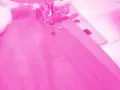 Macchina da cucire al lavoro per cucire una gonna di tulle rosa.
