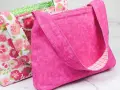 Two handmade fabric bags, one pink with a floral pattern, the other solid pink with a plaid lining.