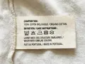 Etichetta con simboli tessuti: lavaggio 30°, non candeggiare, stirare a bassa temperatura, non lavare a secco, non asciugare in asciugatrice. 100% cotone biologico, fatto in Portogallo.