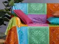 Un modo creativo per coprire una poltrona con un foulard colorato, creando un patchwork vivace.