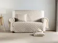 Divano con copridivano trapuntato color crema. Scopri come lavare copridivano in lavatrice per mantenerlo sempre fresco e pulito.
