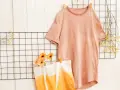 T-shirt rosa e borsa con sfumature arancioni, ispirazione per come tingere un vestito. Fiori e rametti secchi decorano.