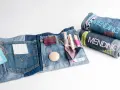 Kit per rammendo creativo jeans: tasche con fili, aghi, tessuti e bottoni. Arrotolati, altri kit con scritta "Mending Kit".