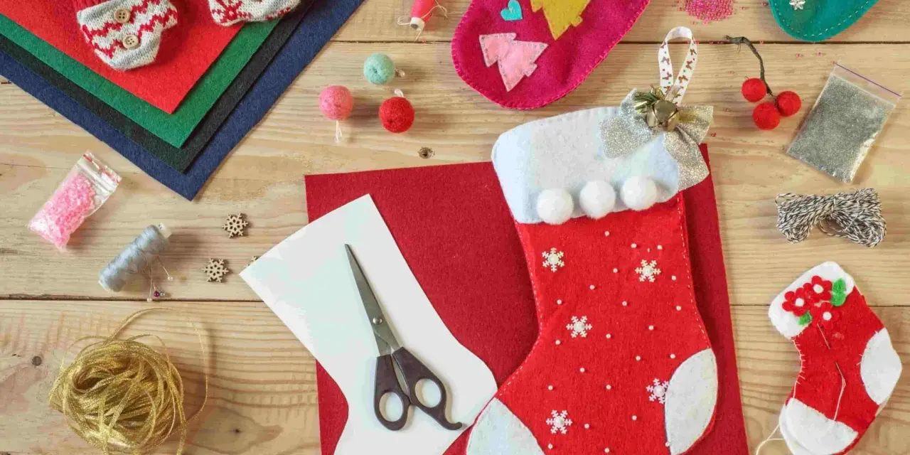 Materiali per calze Befana personalizzate fai da te: pannolenci, forbici, filo, perline e decorazioni per creare la tua calza unica.