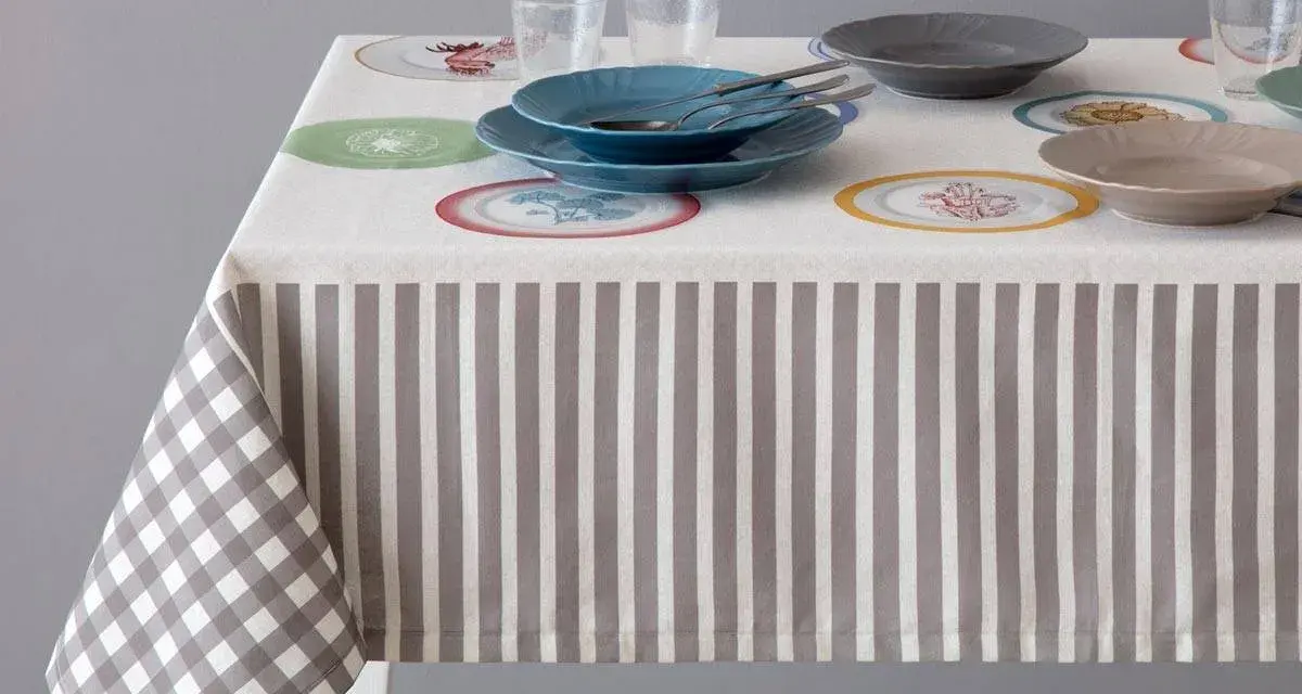 Tovaglia a righe e quadretti con piatti colorati. Un'idea per sapere come smacchiare le tovaglie e mantenerle sempre perfette.