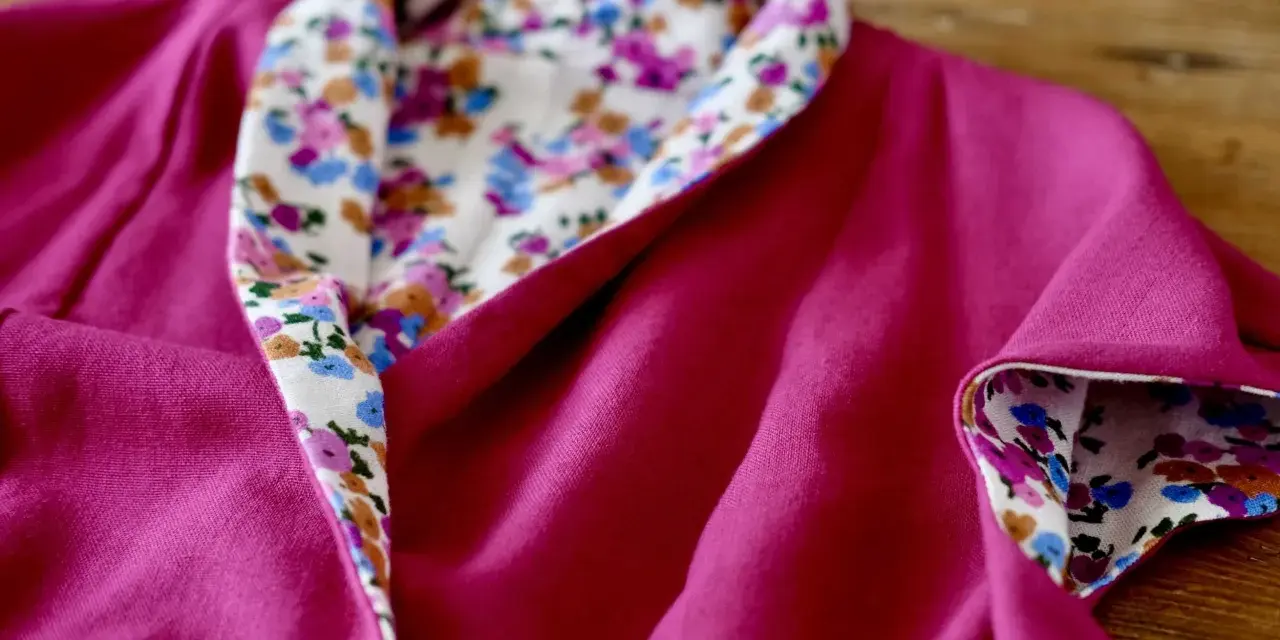 Dettaglio di un vestito estivo semplice fucsia con colletto e polsini foderati di tessuto floreale. Perfetto per imparare come cucire un vestito estivo semplice.