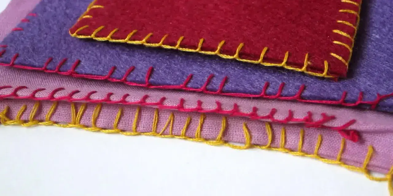 Tessuti colorati sovrapposti, rifiniti con un punto coperta giallo, rosa e rosso.