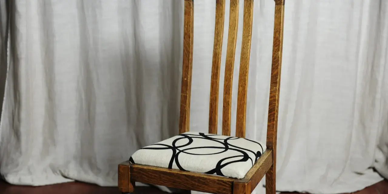 Sedia in legno con seduta imbottita e fantasia geometrica. Un esempio di come tappezzare sedie per rinnovare l'arredo.