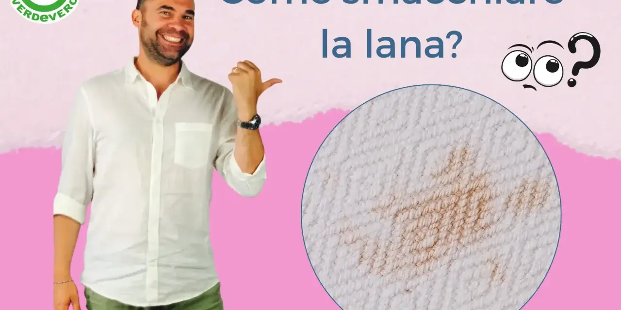 Uomo sorridente indica una macchia su tessuto di lana. Impara come smacchiare la lana con consigli pratici.