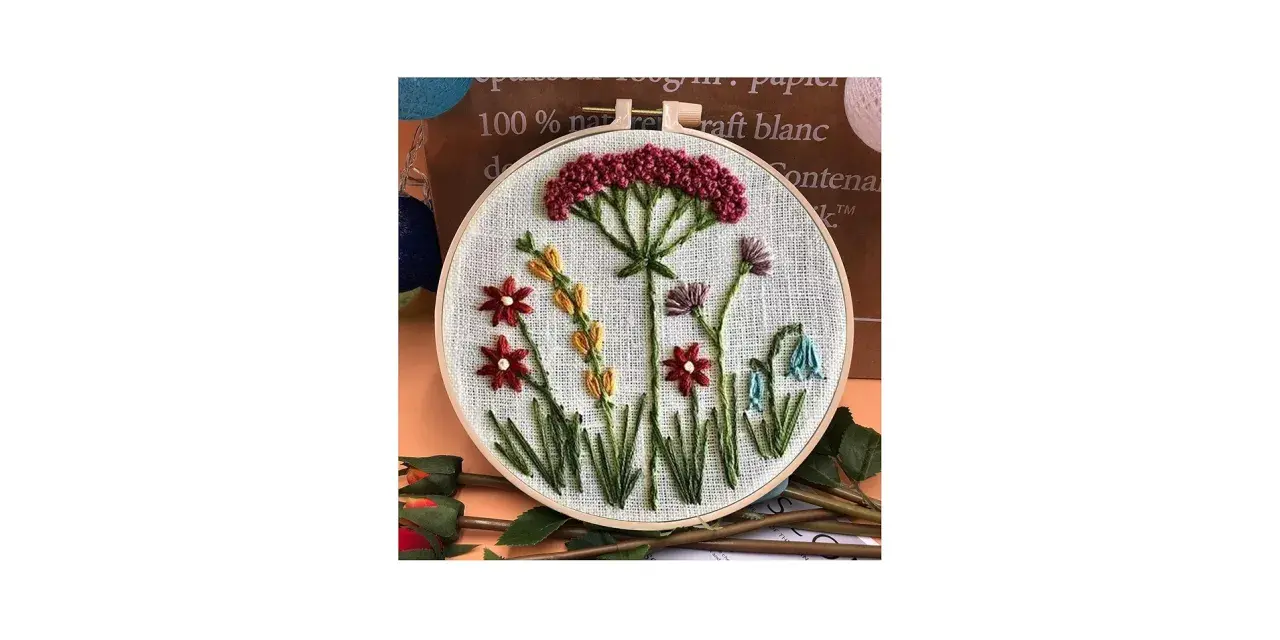 Embroidery hoop with a simple floral design featuring red, yellow, purple, and blue flowers.