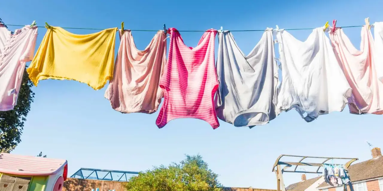 Panni colorati stesi al sole su un filo, un'immagine di vita quotidiana e la gioia di stendere i panni all'aria aperta.