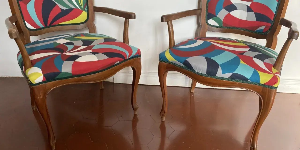 Due sedie con schienale rivestite con tessuto colorato e geometrico, un'idea per come rivestire una sedia con schienale.