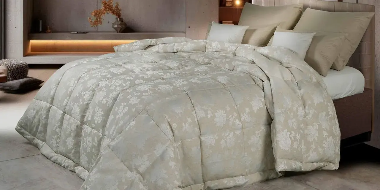 Un piumone matrimoniale con un delicato motivo floreale color crema, morbido e accogliente. Chissà quanto pesa un piumone matrimoniale così bello?