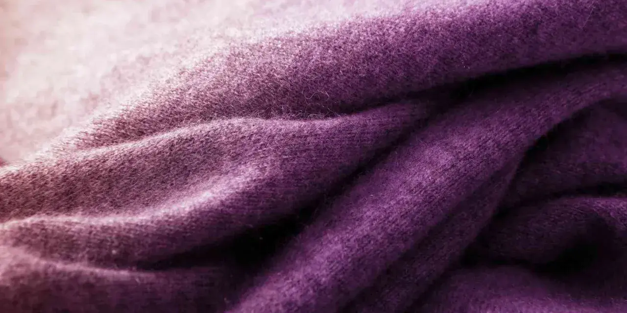 Tessuto di lana viola sfumato, ideale per imparare come tingere un maglione di lana e ottenere questo colore vibrante.
