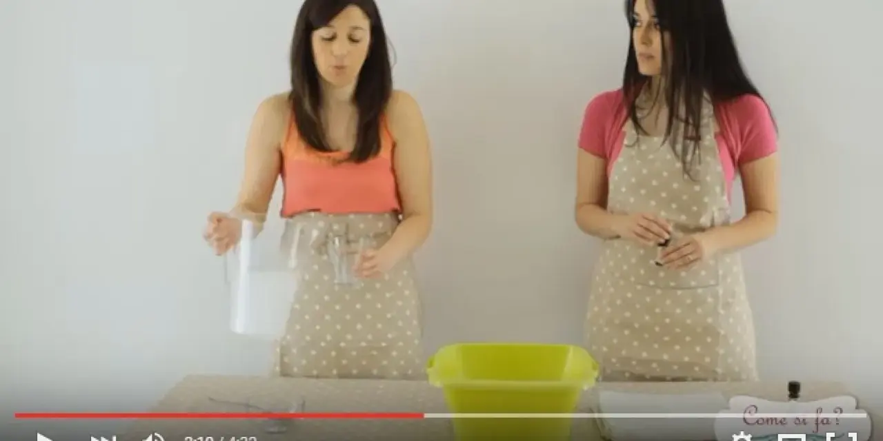 Due donne preparano il necessario per sbiancare asciugamani in lavatrice. Una versa un liquido da una brocca in un bicchiere.
