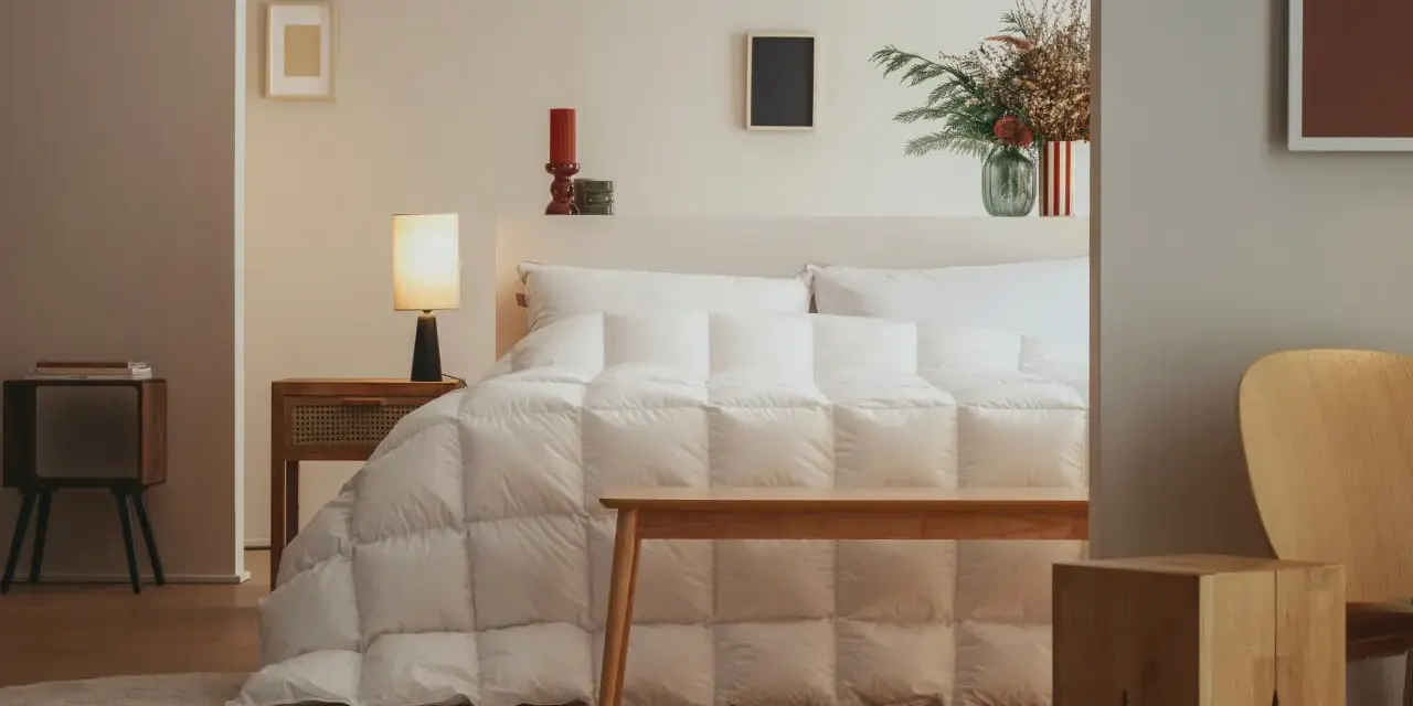 Un letto accogliente con un piumone bianco trapuntato, pronto per accogliere la parte tonda del piumone dove va, creando un nido perfetto.