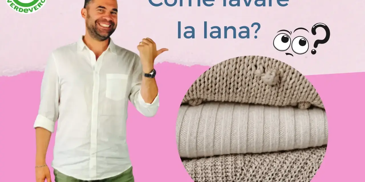 Uomo sorridente indica come lavare lana a mano. Pile di maglioni in primo piano.