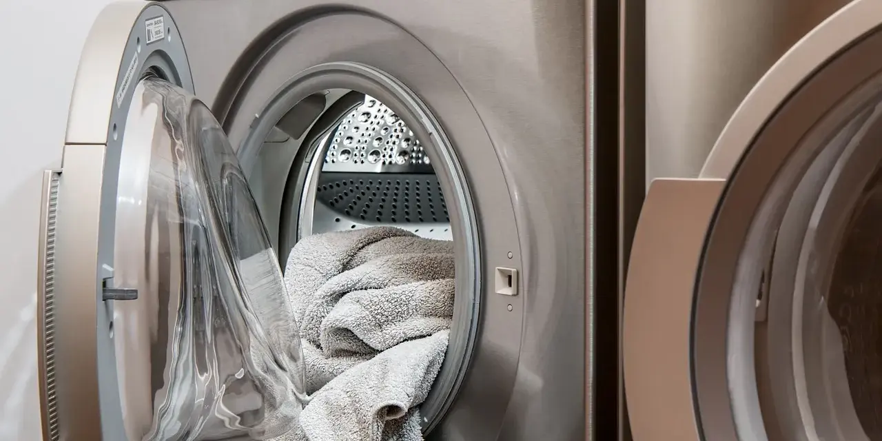 Lavatrice con un tappeto grigio all'interno, pronta per il lavaggio. Scopri come lavare i tappeti in lavatrice per mantenerli freschi e puliti.