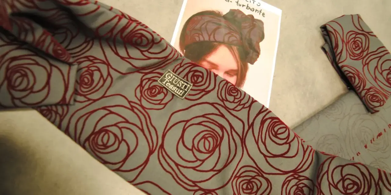 Tessuto grigio con rose rosse, ideale per imparare come fare un turbante di stoffa.