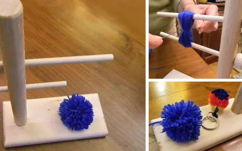 Creazione di pon pon di lana fai da te con un attrezzo in legno. Un pompon blu è pronto, un altro è in lavorazione.