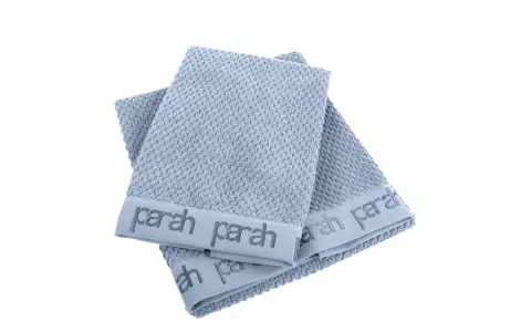 Due asciugamani azzurri con logo "parah" sovrapposti. Sembrano morbidi, ma chissà se sono asciugamani che non asciugano.
