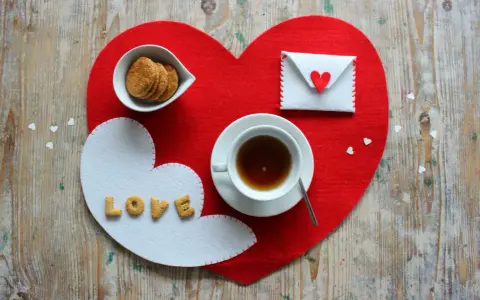 Tovagliette colazione fai da te a forma di cuore, con biscotti, tè e una busta decorata.