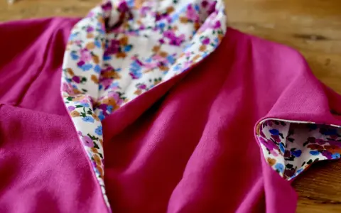 Dettaglio di un vestito estivo semplice fucsia con colletto e polsini foderati di tessuto floreale. Perfetto per imparare come cucire un vestito estivo semplice.