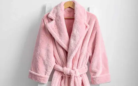 Accappatoio rosa soffice appeso. Scopri come lavare accappatoio in lavatrice per mantenerlo morbido e profumato.