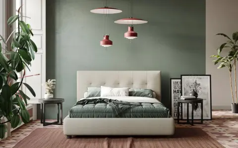 Letto moderno con testiera capitonné, copriletto verde e cuscini bianchi. Parti del letto ben visibili, con comodini e piante.