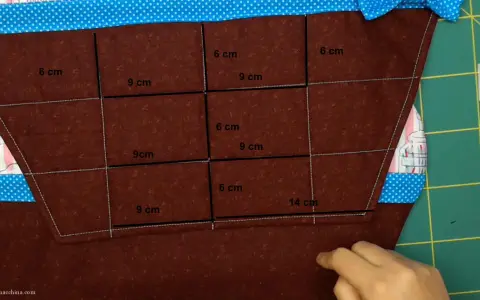 Tovagliette fai da te bambini: tessuto marrone con misure segnate per creare tasche, bordi colorati.