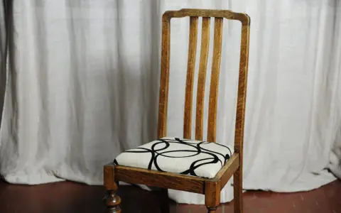 Sedia in legno con seduta imbottita e fantasia geometrica. Un esempio di come tappezzare sedie per rinnovare l'arredo.