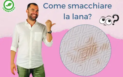Uomo sorridente indica una macchia su tessuto di lana. Impara come smacchiare la lana con consigli pratici.