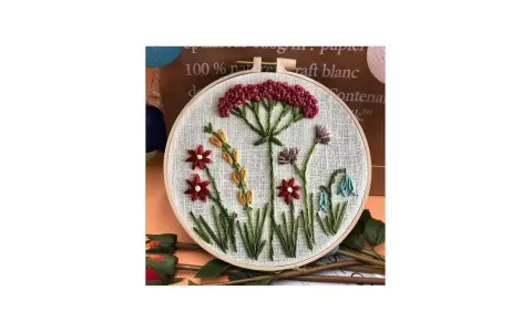 Embroidery hoop with a simple floral design featuring red, yellow, purple, and blue flowers.