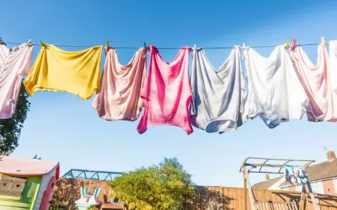 Panni colorati stesi al sole su un filo, un'immagine di vita quotidiana e la gioia di stendere i panni all'aria aperta.