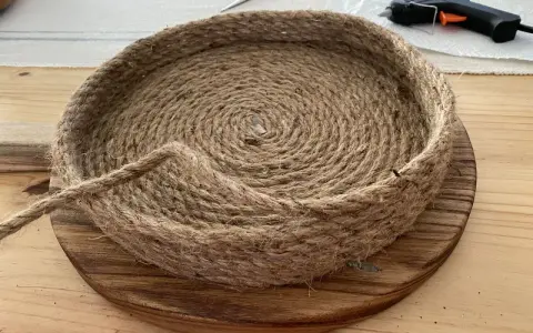 Come fare un cesto con la corda: un progetto fai-da-te con corda di juta, base in legno, forbici e colla a caldo.