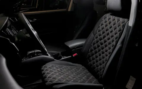 Interno auto con sedili neri trapuntati, il miglior tessuto per sedili auto per un comfort elegante.