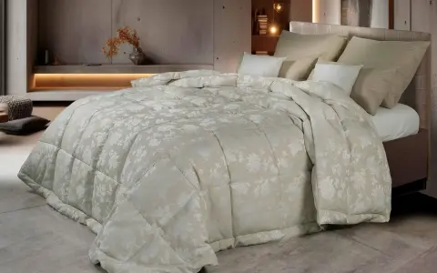 Un piumone matrimoniale con un delicato motivo floreale color crema, morbido e accogliente. Chissà quanto pesa un piumone matrimoniale così bello?
