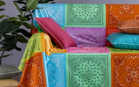 Un modo creativo per coprire una poltrona con un foulard colorato, creando un patchwork vivace.