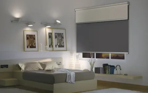 Camera da letto moderna con letto, quadri e un'ampia finestra con tende a rullo grigie e bianche.