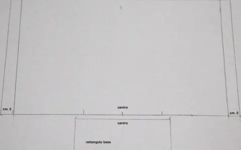 Cartamodello porta pannolini fai da te: schizzo con linee, misure (cm 5) e indicazioni "centro" e "rettangolo base" per creare un pratico contenitore.