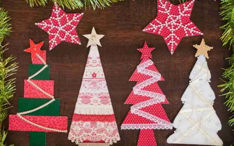 Alberi di Natale fai da te in stoffa, decorati con pizzi e stelle, creano un'atmosfera festiva e artigianale.