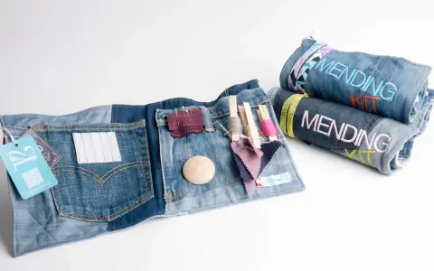 Kit per rammendo creativo jeans: tasche con fili, aghi, tessuti e bottoni. Arrotolati, altri kit con scritta "Mending Kit".