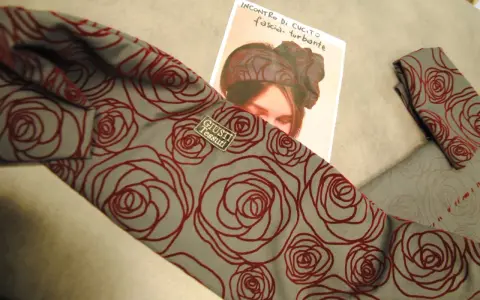 Tessuto grigio con rose rosse, ideale per imparare come fare un turbante di stoffa.